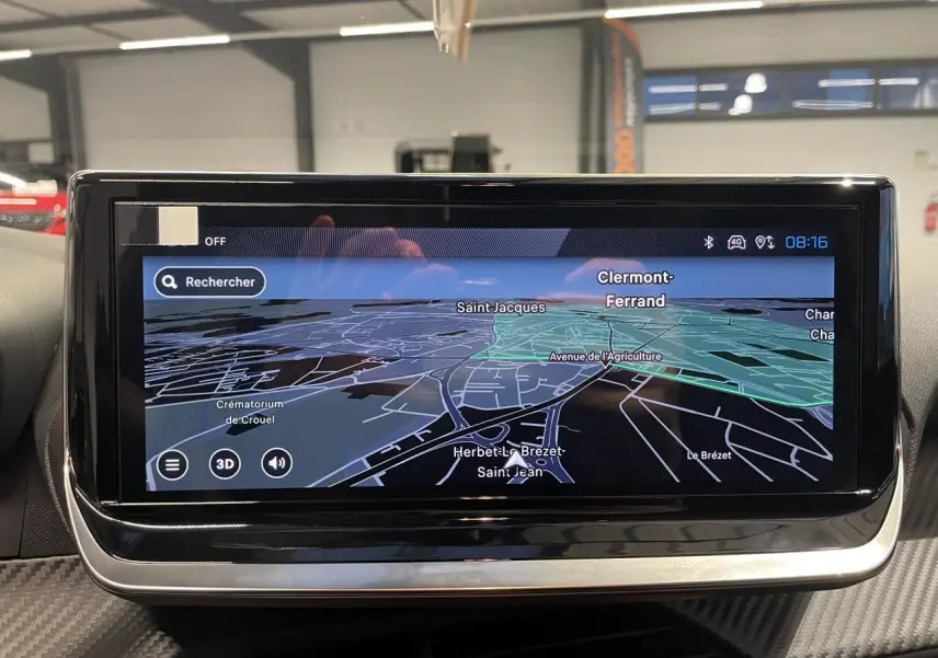 Écran tactile central du tableau de bord de la Peugeot 208 gris Selenium affichant la navigation GPS en 3D.