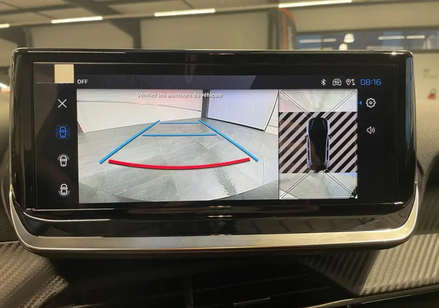 Écran tactile intérieur affichant la caméra de recul et vue 360° de la Peugeot 208 gris selenium, tableau de bord visible.