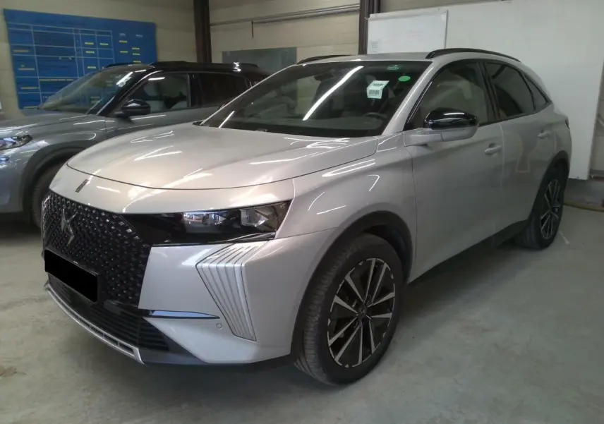 DS7 2025 Cristal Pearl en 3/4 avant droit, avec calandre noire distinctive et jantes alliage noires.