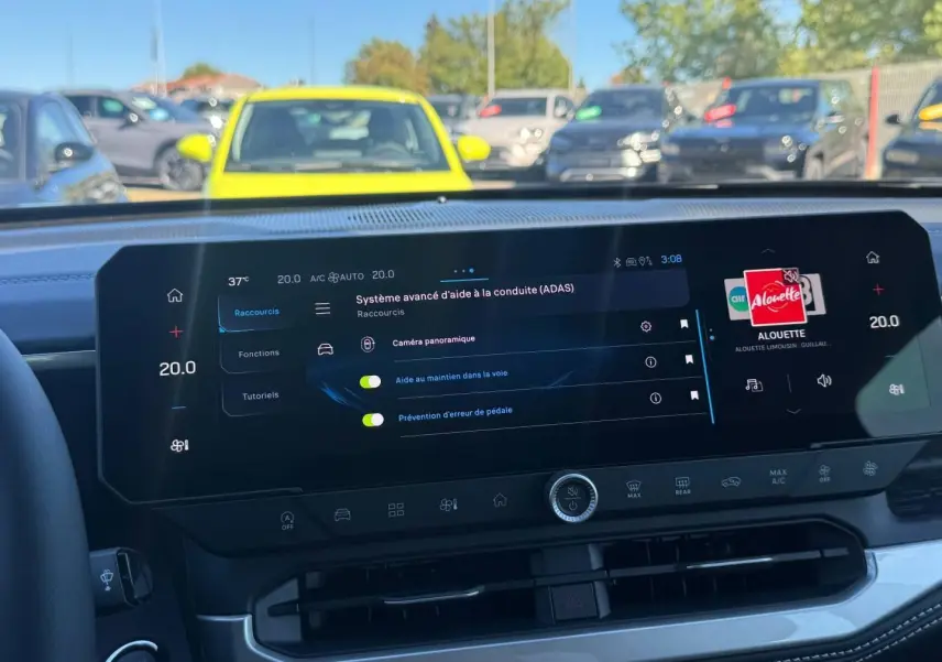 Vue intérieure du tableau de bord du Jeep Compass 2026, écran tactile affichant les aides à la conduite, volant partiellement visible.