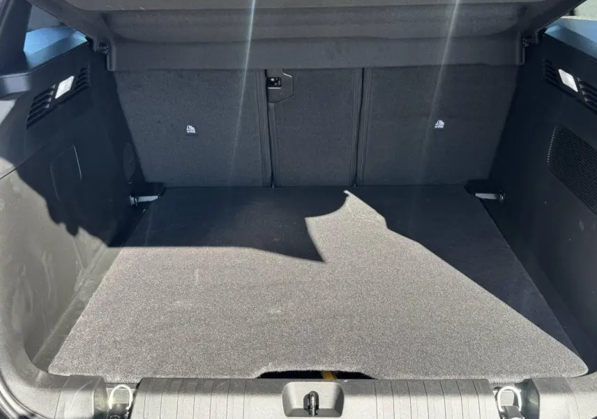 Coffre ouvert vu de l'arrière du Jeep Compass 2026, espace de chargement propre avec tapis noir et habillage sombre.