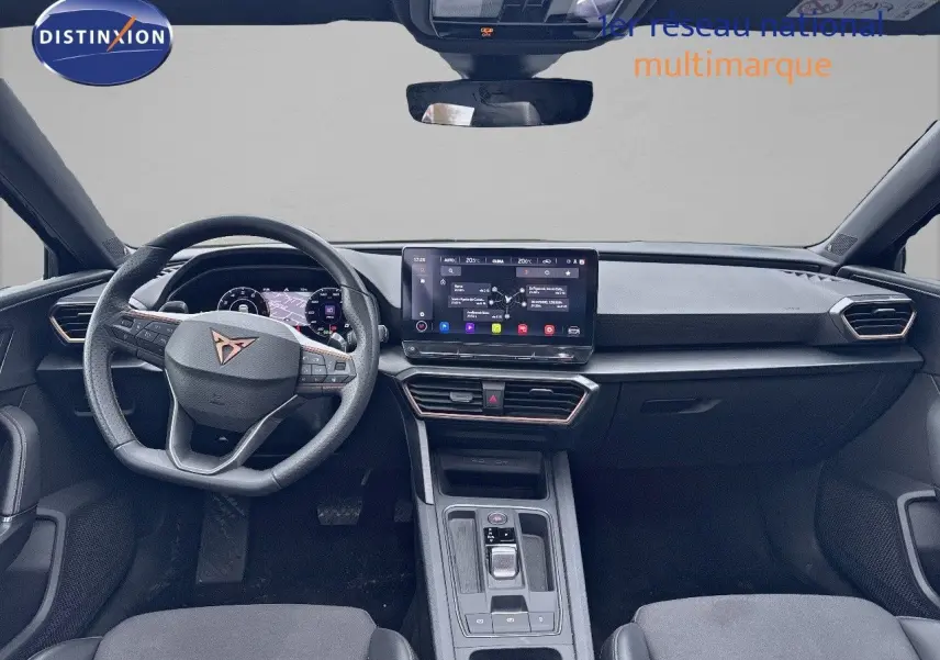 Intérieur avant du CUPRA LEON ST 2024 avec tableau de bord numérique et écran tactile central, volant cuir noir.