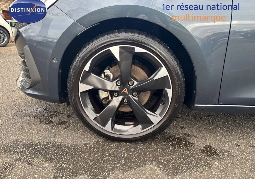 Gros plan sur la roue avant gauche de la CUPRA LEON ST 2024 gris magnetic metal avec jante alliage bicolore distinctive.