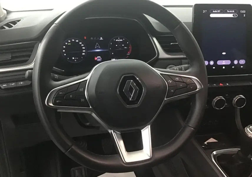 Vue centrée sur le volant noir du Renault Captur 2024 avec tableau de bord numérique et écran tactile vertical.