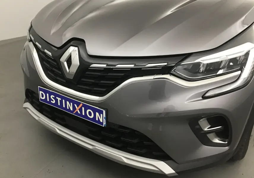 Gros plan avant droit du Renault Captur gris Cassiopée avec calandre noire et éclairage LED distinctif.