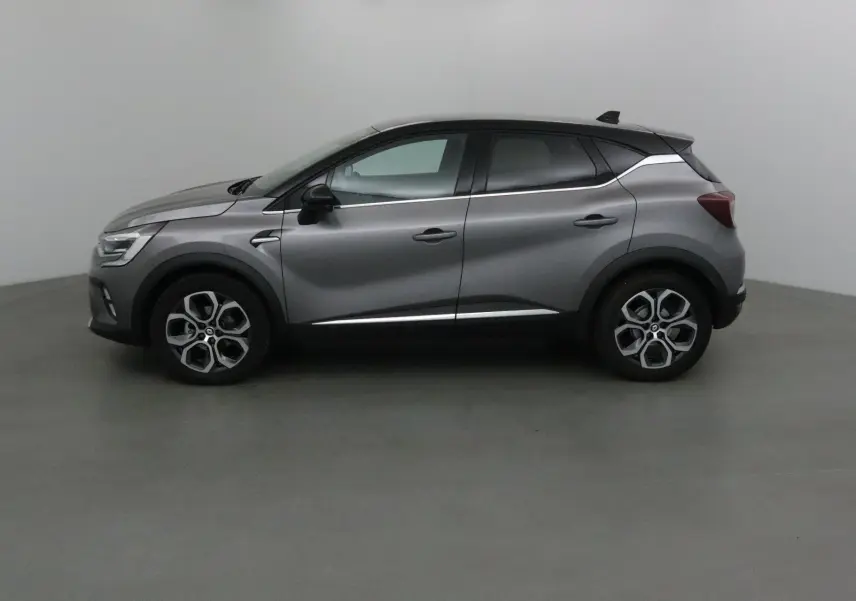 Profil côté gauche du Renault Captur 2024 gris Cassiopée avec toit noir et jantes alliage 18 pouces.