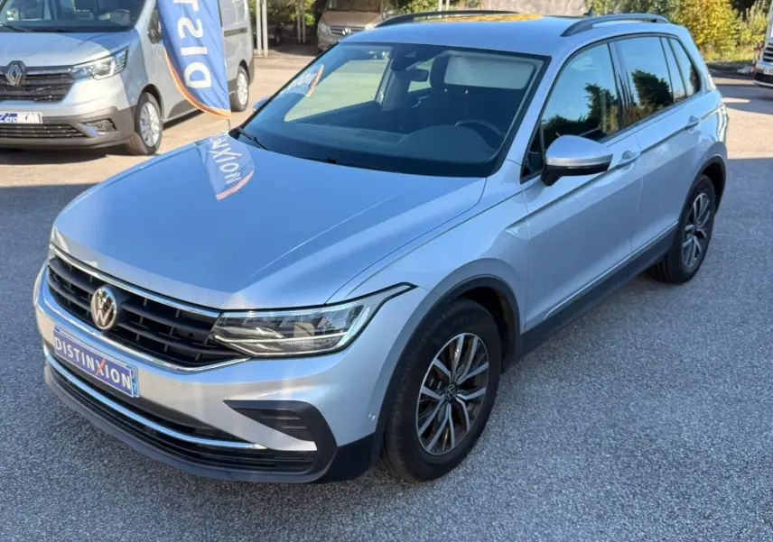 Volkswagen Tiguan 1.5 TSI 2021 en reflet argent, vue 3/4 avant droit avec calandre et phares LED distinctifs.