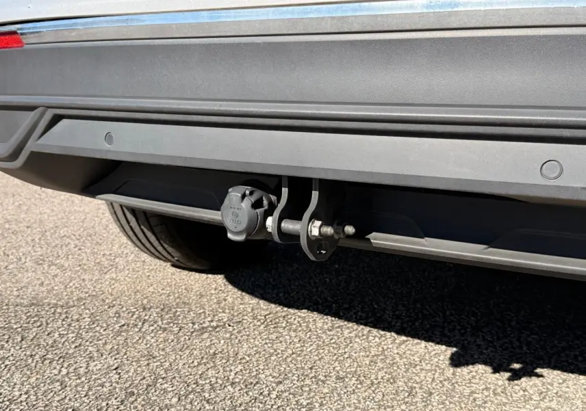 Gros plan sur l'attelage arrière du Volkswagen Tiguan 1.5 TSI 150ch Life DSG7 en reflet argent, avec prise électrique visible.