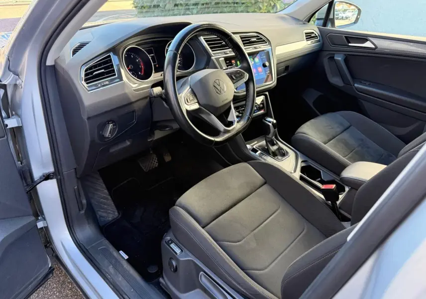 Intérieur avant droit du Volkswagen Tiguan 1.5 TSI 2021 en reflet argent, sièges Ergo Active et tableau de bord moderne.