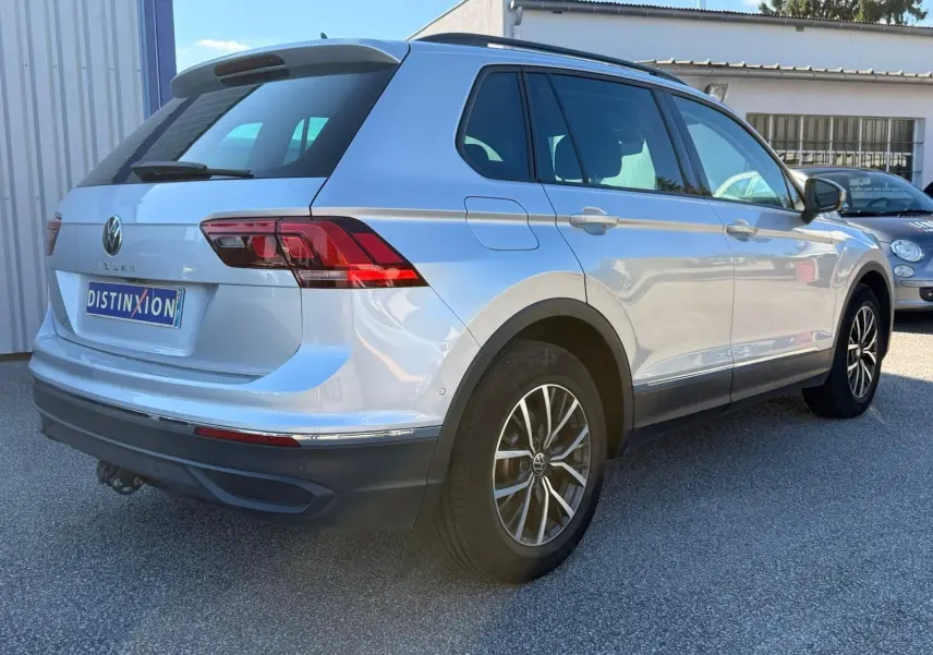 Volkswagen Tiguan 1.5 TSI argent en 3/4 arrière droit, avec jantes alliage et feux arrière LED distinctifs.