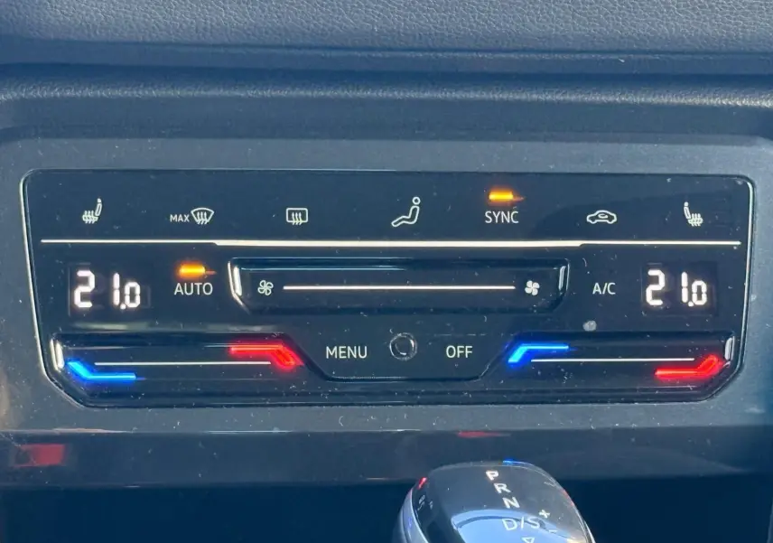 Panneau de commande de la climatisation automatique du Volkswagen Tiguan 1.5 TSI 150CH LIFE DSG7, affichant 21°C et fonctions activées.