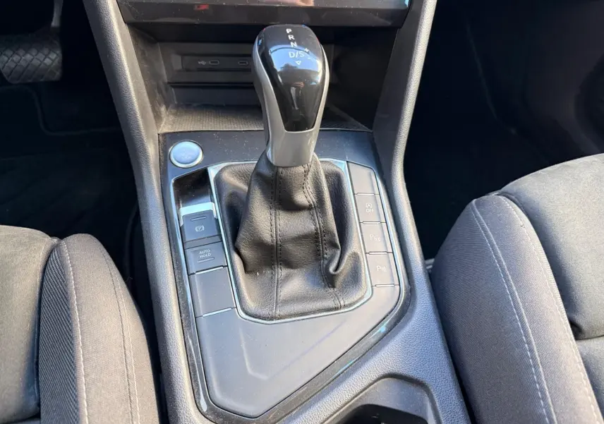 Le levier de vitesses automatique noir du Volkswagen Tiguan 1.5 TSI 150CH LIFE DSG7 vu en gros plan au centre console.