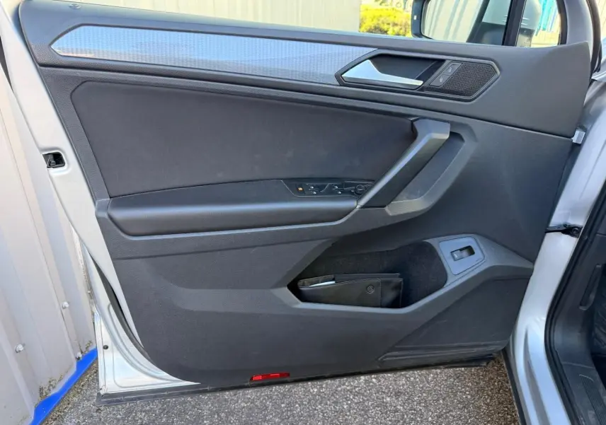 Vue rapprochée de la porte avant gauche du Volkswagen Tiguan 2021 en reflet argent avec garniture intérieure noire.