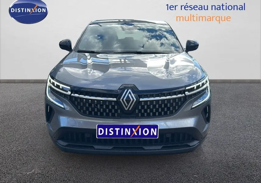 Vue frontale du Renault Austral gris schiste 2023 avec calandre à damier et feux LED distinctifs allumés.