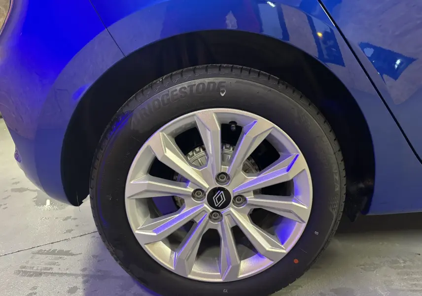 Gros plan sur la roue avant gauche d'une Renault Clio 2024 bleu iron avec jante alliage et pneu Bridgestone.