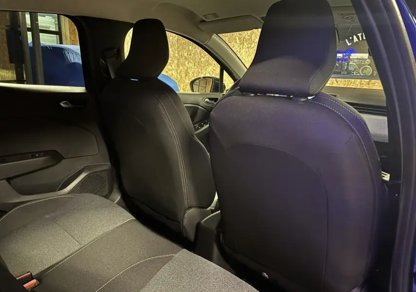 Vue intérieure arrière de la Renault Clio 2024 en tissu gris noir, montrant les dossiers des sièges avant et la banquette arrière.