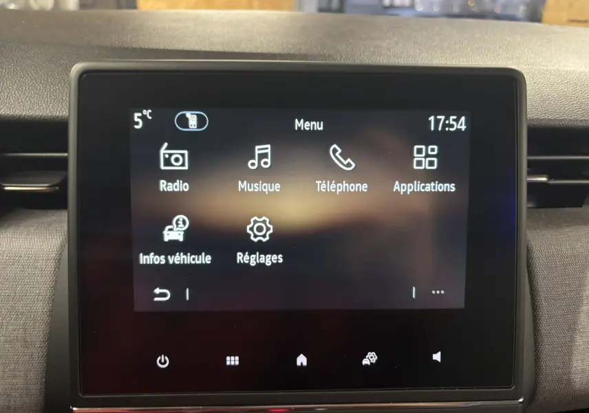 Écran tactile central de la Renault Clio 2024 affichant le menu principal avec options radio, musique, téléphone et réglages.