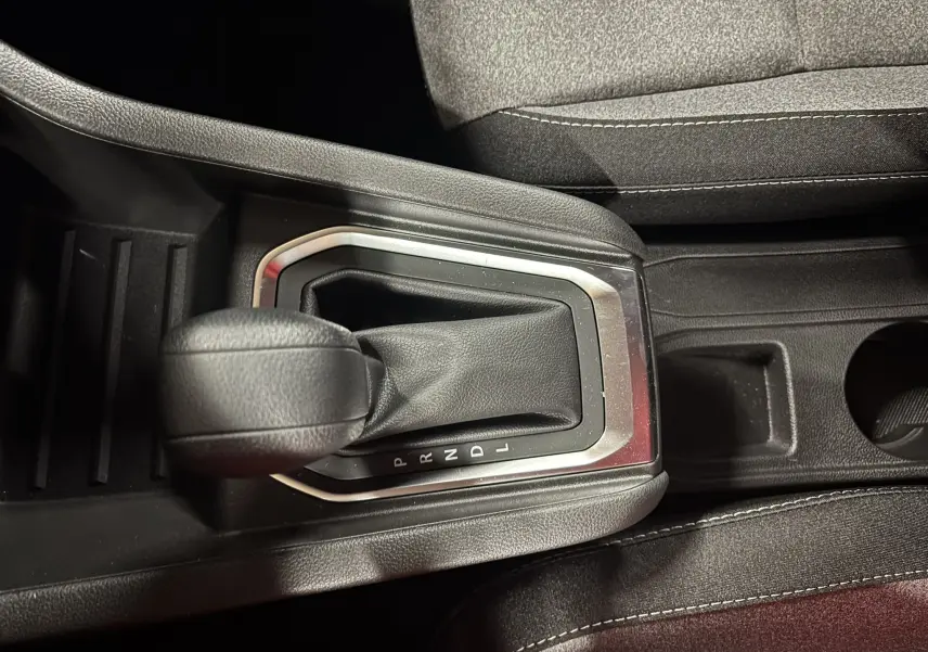 Le levier de vitesse automatique noir de la Renault Clio TCE 90CH X-TRONIC Evolution 2024 vu de dessus, entouré de garniture argentée.