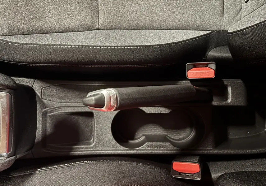 Vue plongeante sur le frein à main et les sièges gris noir en tissu de la Renault Clio TCE 90CH X-TRONIC Evolution 2024.