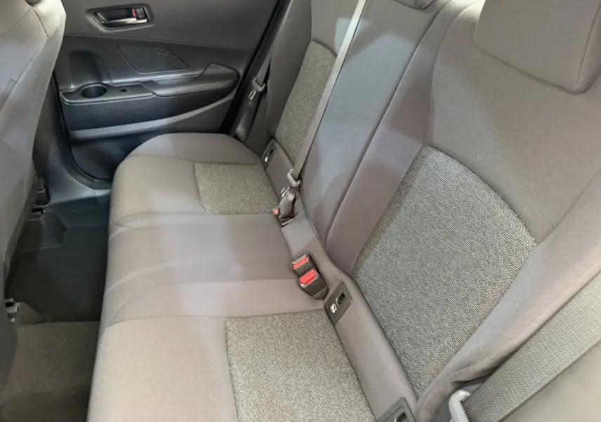 Vue intérieure côté gauche montrant la banquette arrière grise du Toyota C-HR 1.8 Hybride 140 Dynamic 2024.