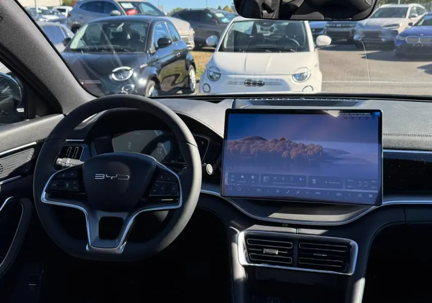 Vue intérieure avant du BYD SEAL U 1.5 DM-i 324ch Design AWD avec volant multifonction et grand écran tactile central.