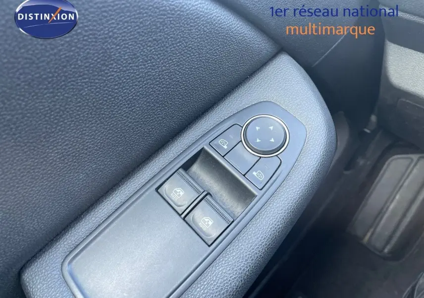 Gros plan sur les commandes des vitres électriques côté conducteur d'une Renault Clio Société blanc glacier, intérieur noir.