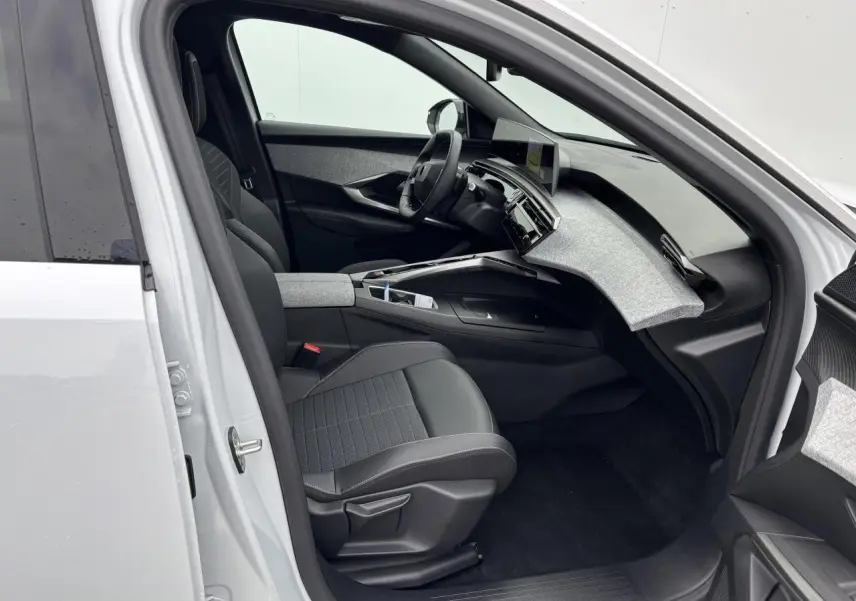 Intérieur côté conducteur du Peugeot 3008 blanc Okenite 2024, avec tableau de bord tissu gris et sièges noirs.