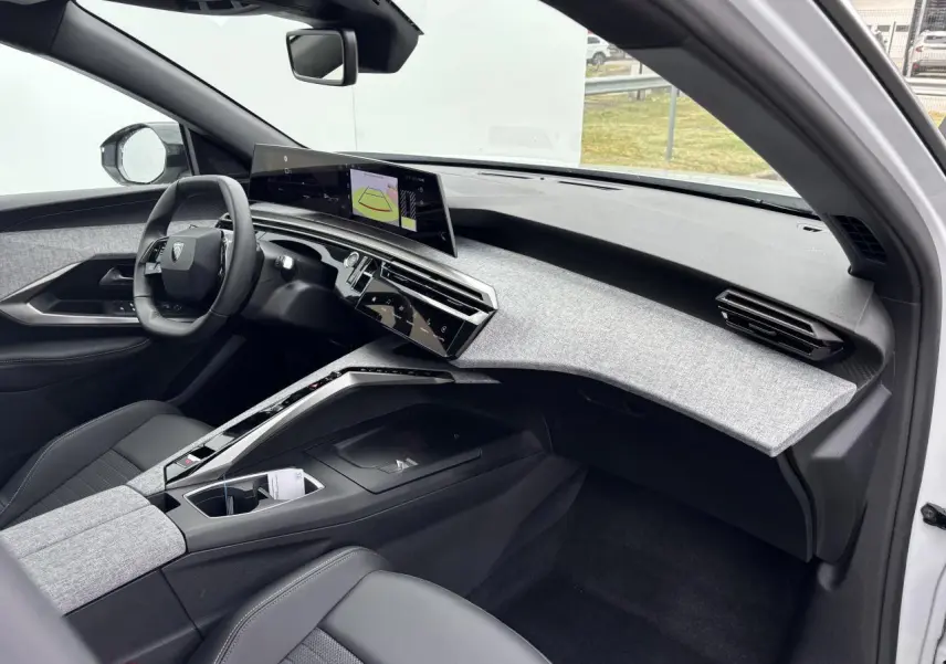 Intérieur avant droit du Peugeot 3008 blanc Okenite 2024, tableau de bord tissu gris clair et écran incurvé flottant.