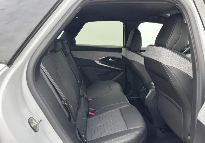 Vue intérieure arrière côté gauche du Peugeot 3008 blanc Okenite 2024 avec sellerie mixte tissu et cuir noir.