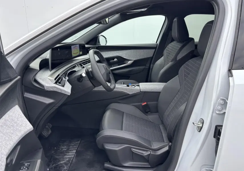 Intérieur avant droit du Peugeot 3008 blanc Okenite 2024 avec sellerie tissu gris et tableau de bord moderne.