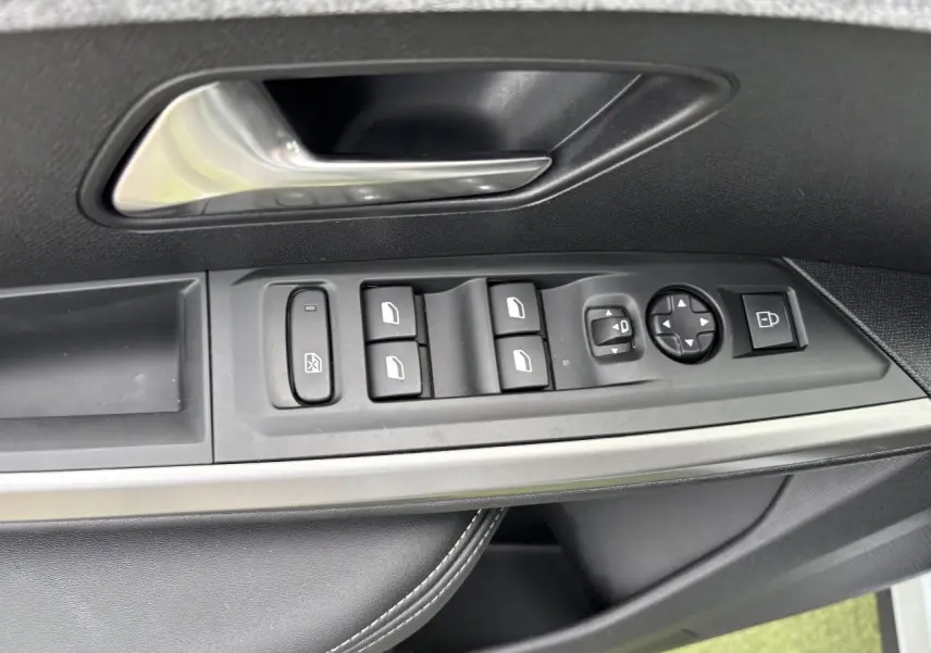 Gros plan sur la commande des vitres et rétroviseurs côté conducteur d'un Peugeot 3008 blanc Okenite 2024.