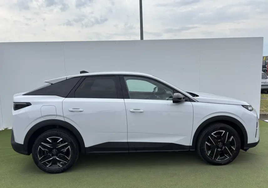 Profil droit du Peugeot 3008 blanc Okenite 2024 avec jantes alliage noires et toit noir contrasté.