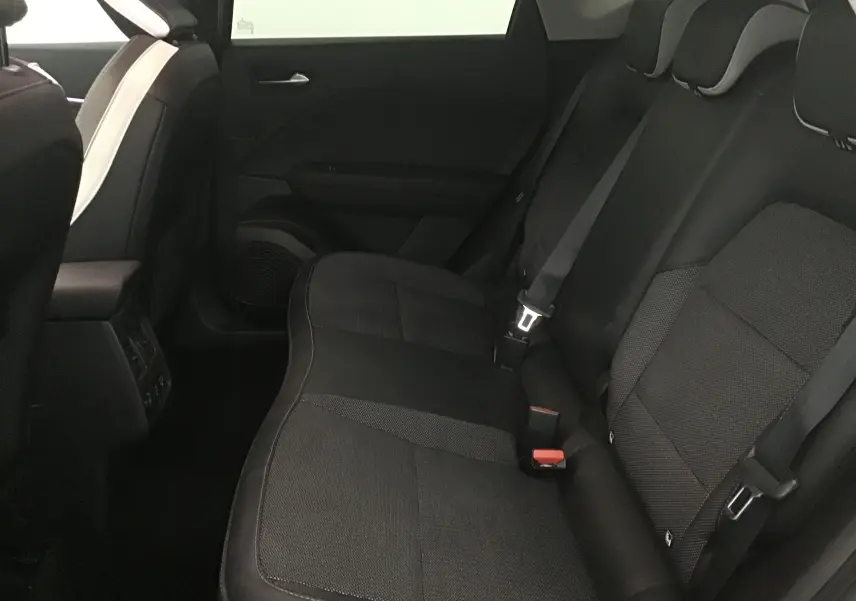 Vue intérieure arrière du Renault Captur 2024 avec sièges noirs en tissu et ceintures de sécurité visibles.