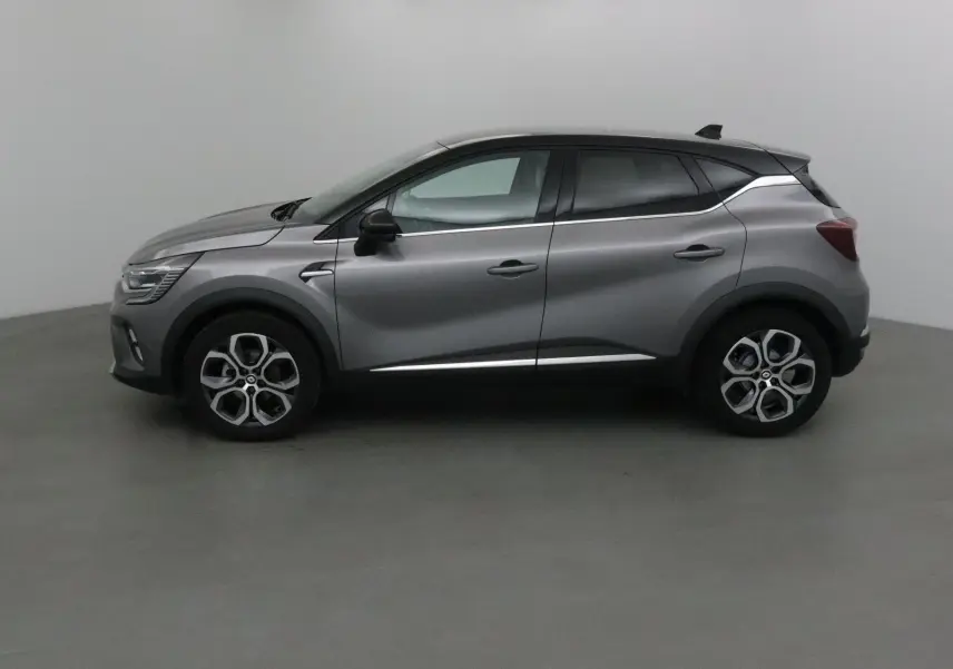 Profil latéral droit d'un Renault Captur 2024 gris Cassiopée avec toit noir et détails chromés.
