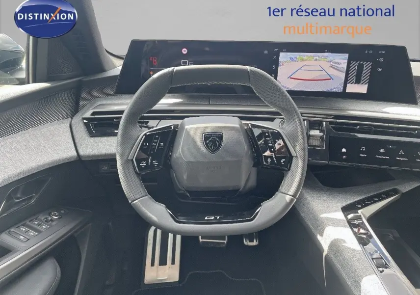 Vue intérieure centrée sur le volant GT et le tableau de bord numérique du Peugeot 5008 Hybrid noir perle métal.