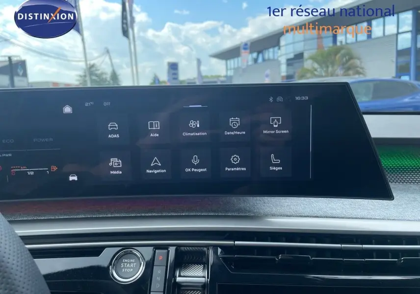 Vue intérieure du tableau de bord du Peugeot 5008 Hybrid 2025 avec écran tactile et bouton start/stop, ambiance moderne et épurée.