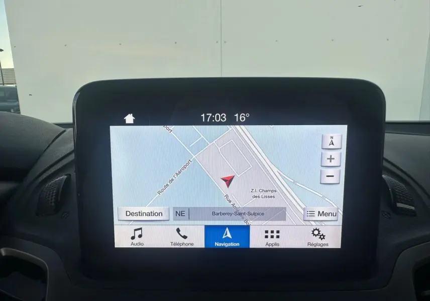 Écran tactile central du tableau de bord du Ford Transit Connect blanc, affichant la navigation GPS en extérieur.