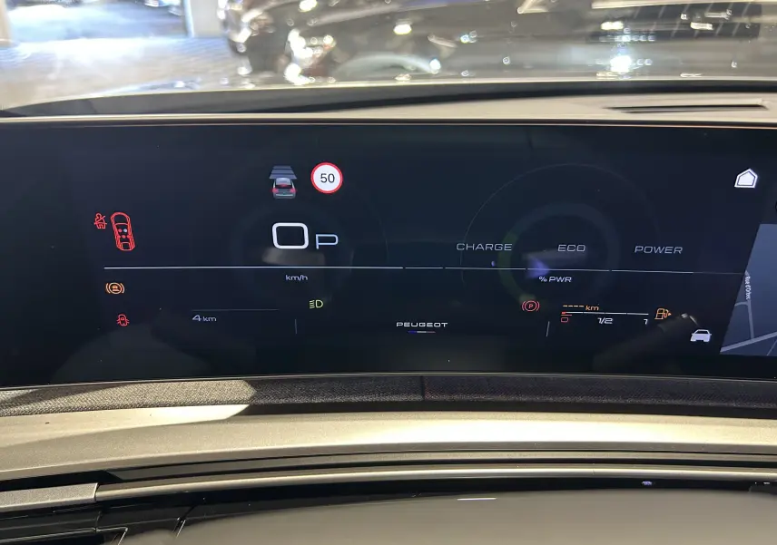 Vue rapprochée du tableau de bord numérique du Peugeot 3008 gris Artense, affichant les indicateurs de conduite et navigation.