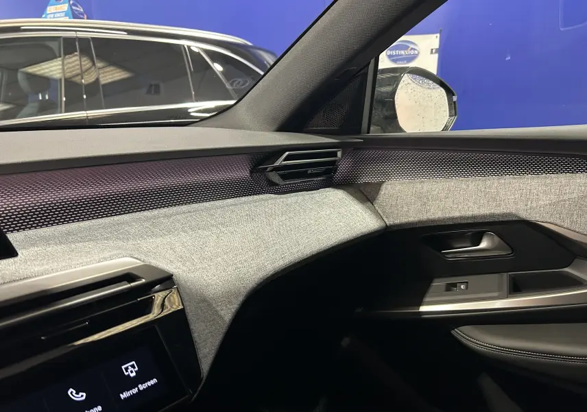 Vue intérieure côté passager du Peugeot 3008 2025 avec tableau de bord et garnitures tissu gris clair et noir.