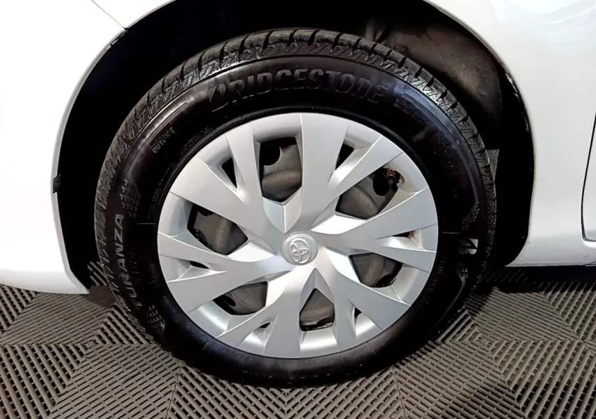 Gros plan sur la roue avant droite blanche d'une Toyota Yaris 1.5 Hybride avec enjoliveur argenté et pneu Bridgestone.