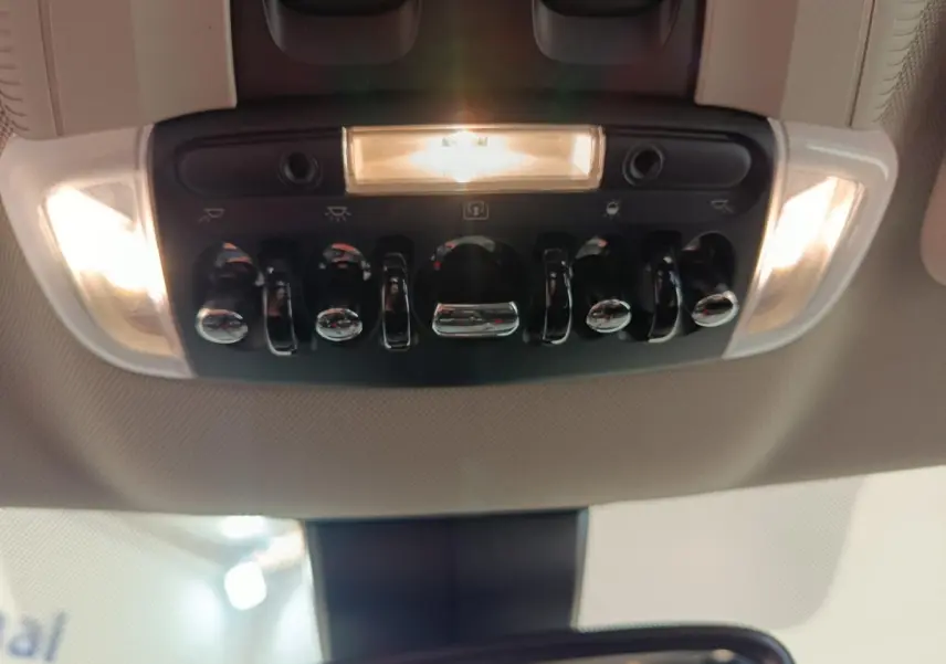 Vue intérieure en gros plan du panneau de commandes de plafonnier avec éclairage, dans un MINI Countryman gris foncé 2023.
