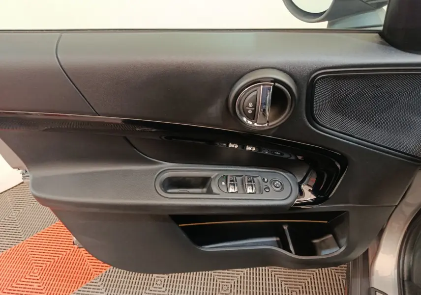 Vue rapprochée de la porte côté conducteur du MINI Countryman gris foncé, avec commandes de vitres et verrouillage intégrées.