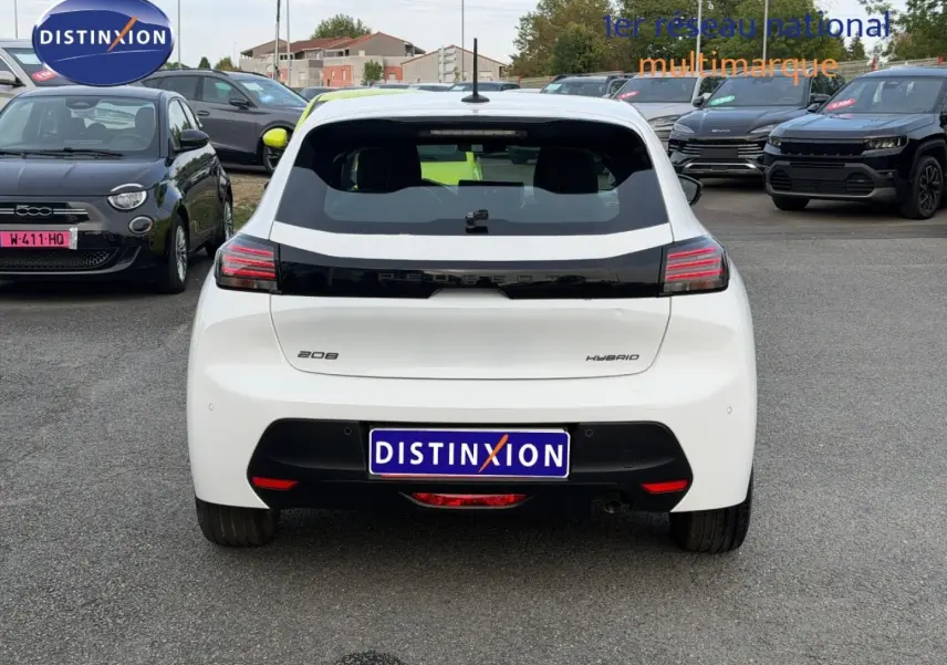 Vue arrière d'une Peugeot 208 hybride blanche Okénite avec feux arrière LED et logo noir brillant au centre.