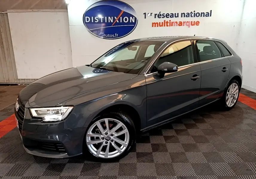 Audi A3 30 TDI gris foncé vue 3/4 avant droit en intérieur avec jantes alliage et phares LED allumés.