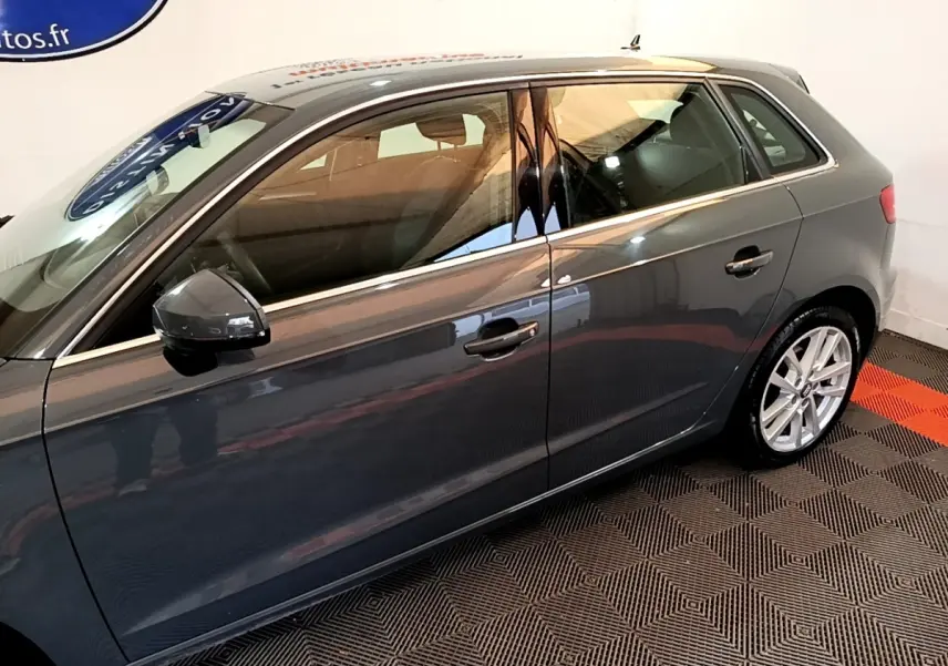 Vue latérale droite d'une Audi A3 gris foncé 2019, mettant en valeur les jantes alliage et les rétroviseurs électriques.