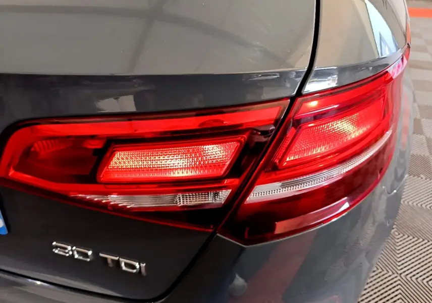 Gros plan sur le feu arrière droit rouge d’une Audi A3 gris foncé 30 TDI 2019 avec logo visible.