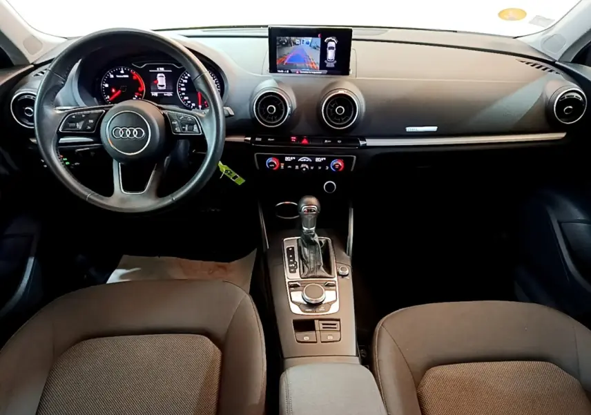 Vue intérieure avant de l'Audi A3 30 TDI Business Line 2019, volant cuir multifonctions et écran central affichant la caméra de recul.
