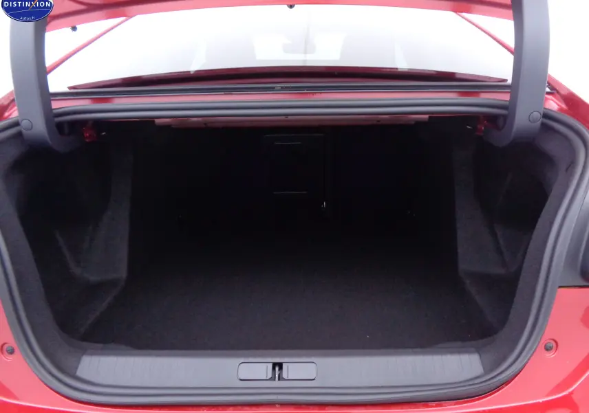 Coffre ouvert vu de l'arrière d'une Citroën C4 X rouge Elixir Métal, espace de rangement spacieux et propre.