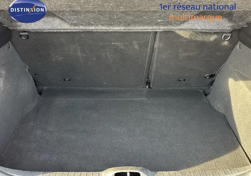 Coffre vide en tissu gris foncé d'une Peugeot 208 noire perle métal vue de l'arrière avec hayon ouvert.