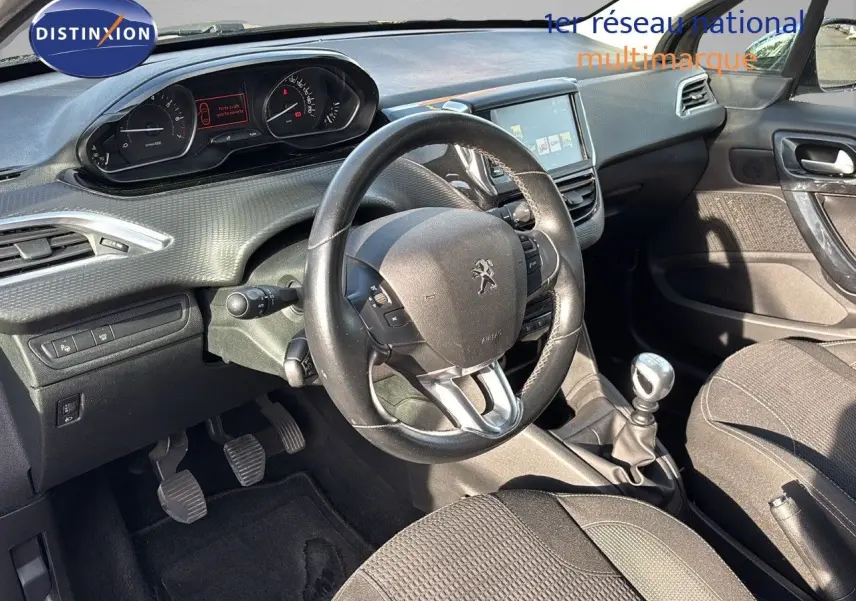 Intérieur de la Peugeot 208 1.2 PureTech 110 Tech Edition 2019, tableau de bord et volant noir côté conducteur.